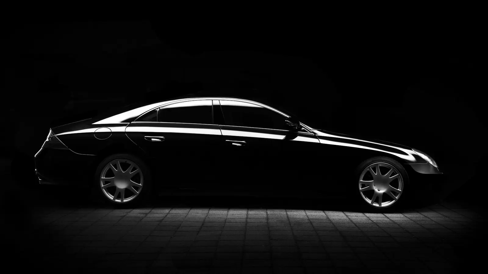 Black sedan after detailing, with deep glossy reflections