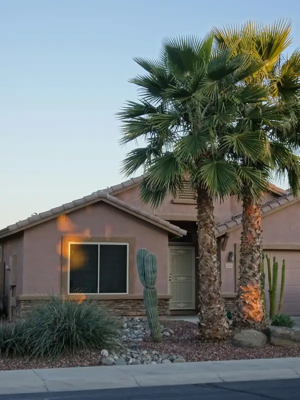 Phoenix-style home with a tile roof, palm trees and desert landscaping