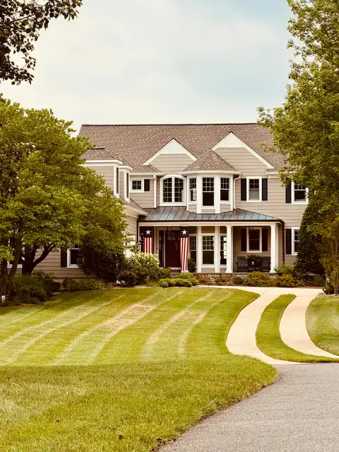 Large home with a perfectly striped front lawn and curving driveway