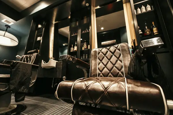 Quilted leather barber chair in a dark, moody shop