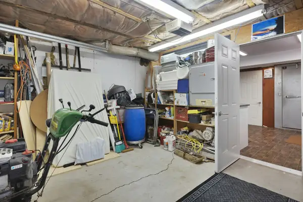 Cluttered garage with shelves, tools and stored items